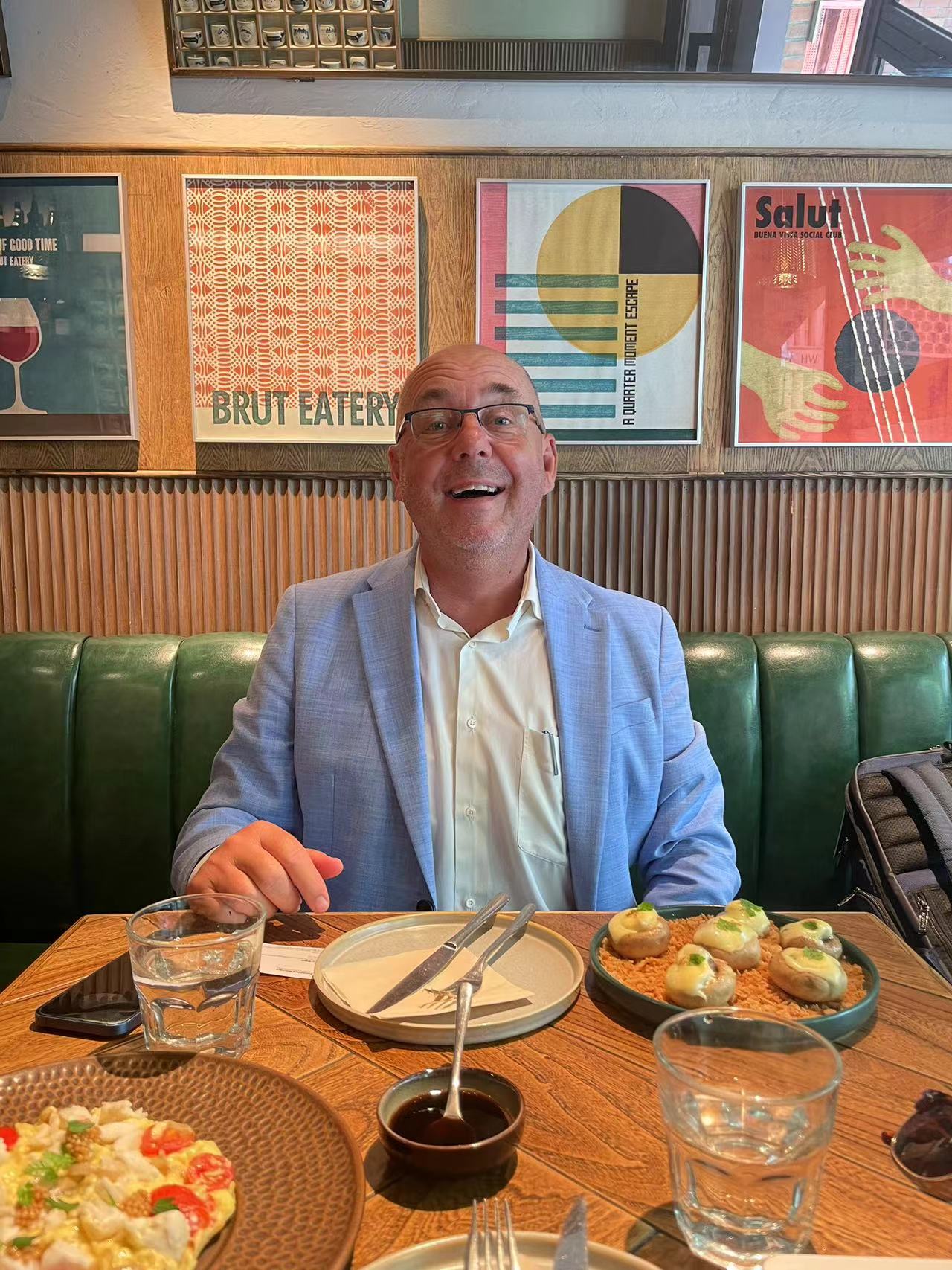 Photo 1: Rene Bos wearing a fine azureous tailored suit during a lunch meeting